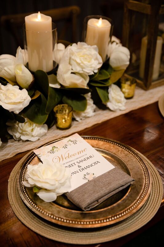 A rustic table setting on a harvest table with antique gold accents and white roses