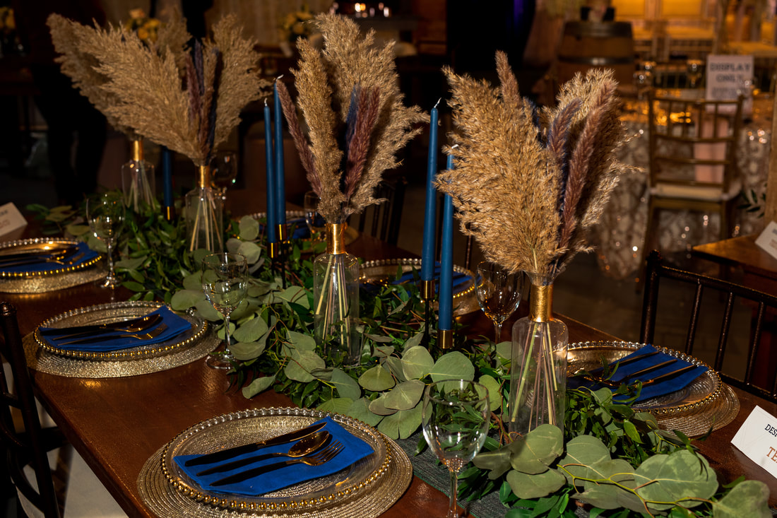 Pampas grass and glass vase centerpiece with blue tapered candles 