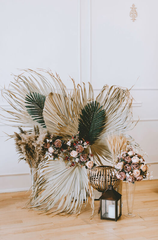 Short palm leaf arrangement with pampas grasss and rose accents